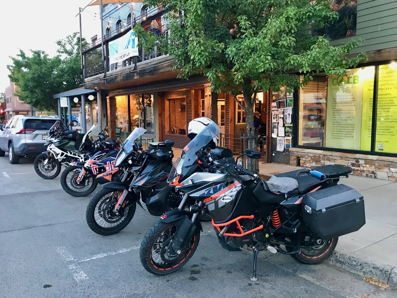 Four KTMs parked Crested Butte street at dusk