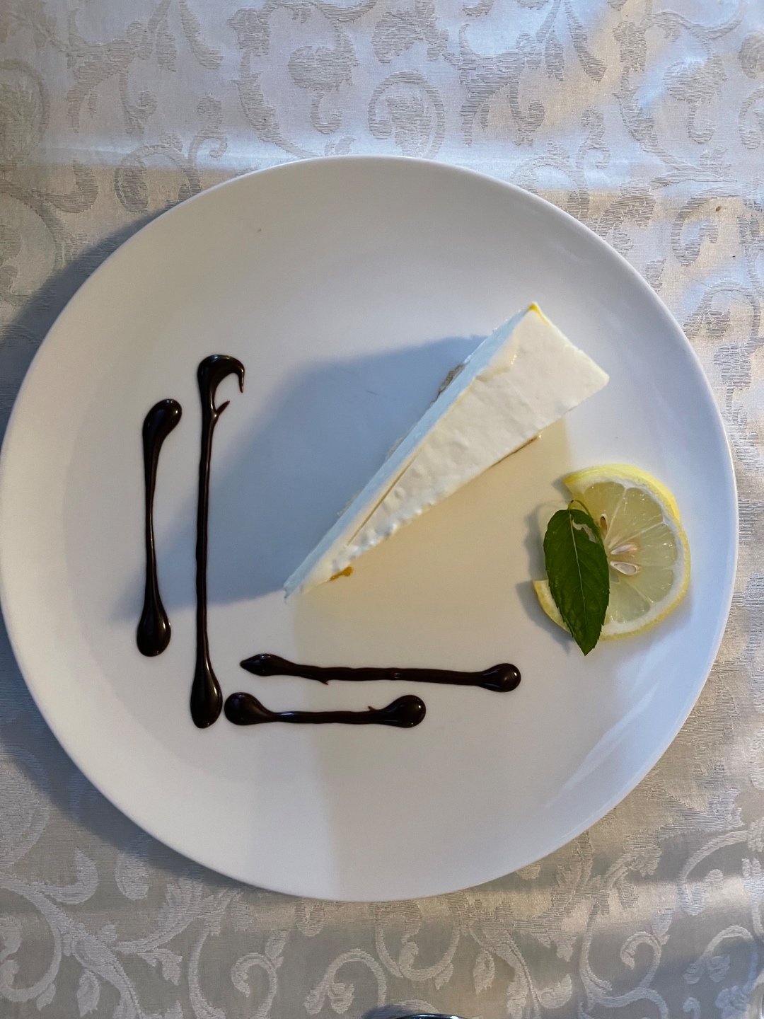 Lemon cheesecake with balsamic drizzle on white china, elegant alpine restaurant